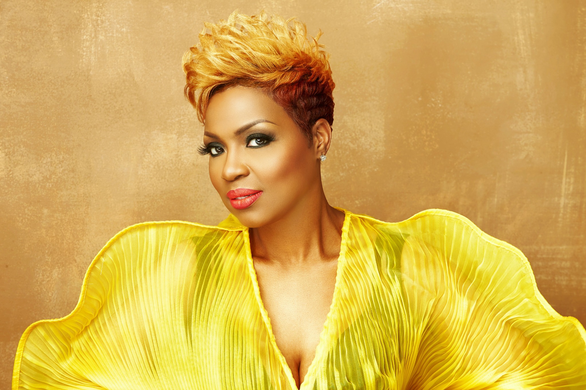 Cassandra Robertson wearing yellow against a gold background